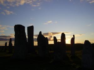a group of wooden posts in a field at sunset at Otter Bunkhouse in Cairisiadar
