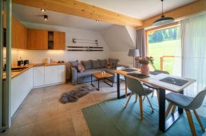 a kitchen and living room with a table and a couch at VIP Apartamenty Mountain Nosal in Zakopane