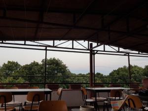 a cafeteria with tables and chairs and a view of trees at Guest House Villa Rose in Primorsko