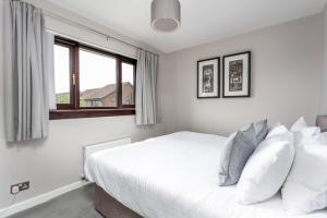 a bedroom with a white bed and a window at The Huntington - Donnini Apartments in Ayr