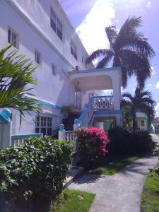 a large white building with flowers in front of it at Beverley's Guest House, Nevis in Nevis