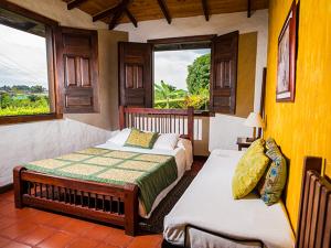 a bedroom with two beds and a window at Finca Rionegro Rancho La Soledad in Montenegro