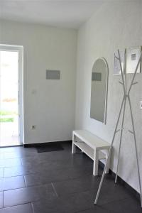ein weißes Zimmer mit einer Bank und einem Spiegel in der Unterkunft Apartments Alma in Pag