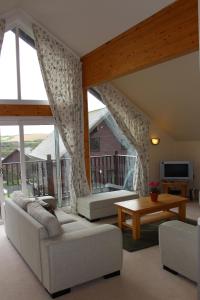 a living room with white furniture and a large window at Peaceful relaxing home with leisure in Saint Columb Major