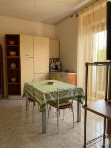 een keuken met een tafel en een aantal stoelen en een tafel en een keuken bij Playa Apartment in Catania