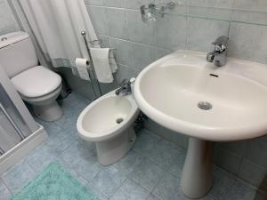 een badkamer met een witte wastafel en een toilet bij Playa Apartment in Catania