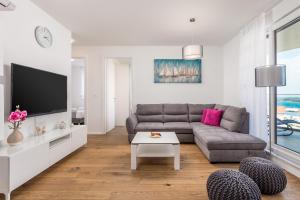 a living room with a couch and a tv at Luxury Apartment Joo & Joo in Murter