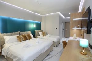Habitación de hotel con 2 camas y TV en Tropical, en Chaniotis
