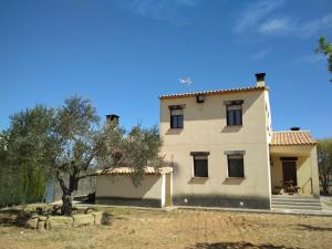 a large white house with a tree in front of it at La Era en Guara in Ibieca