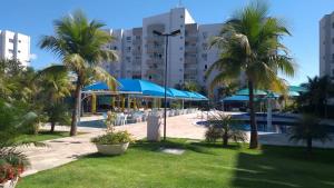 un complexe avec des palmiers et une piscine dans l'établissement Apartamento LAGOA QUENTE FLAT SERVICE, à Caldas Novas