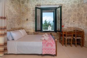 a bedroom with a bed and a window and a table at Traditional House in Kouses in Kousés