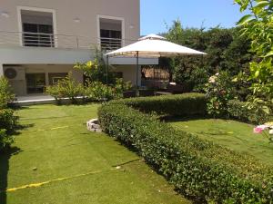 科斯城的住宿－Angel House Apartment，一个带遮阳伞和灌木的花园