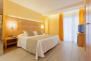 a hotel room with a large bed and a television at Hotel Pimar & Spa in Blanes