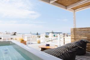 a balcony with a hot tub on a roof at Cosmo Luxe in Mikonos
