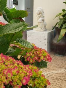 Ein paar Blumen in einem Raum mit einer Statue. in der Unterkunft Locanda Elena in Equi Terme