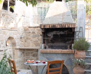 a stone oven in a patio with a table and chairs at Traditional House in Kouses in Kousés