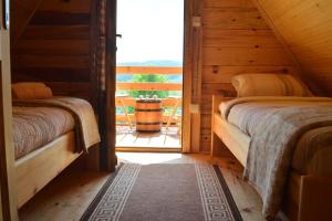 two beds in a wooden room with a window at Drveni raj Uvac in Sjenica