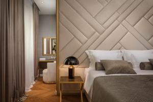 a bedroom with a large bed with a wooden headboard at Five Elements Luxury Rooms in Split