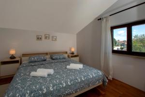 a bedroom with a bed with two pillows and a window at APP FIORELA in Poreč