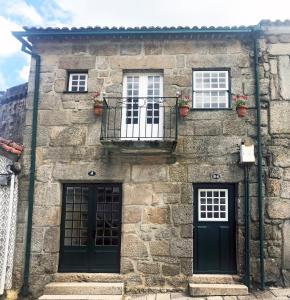 Edificio de piedra con 3 ventanas y balcón en Casa da Muralha Cerveira, en Vila Nova de Cerveira
