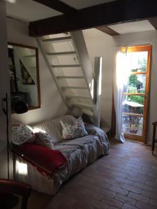 eine Couch in einem Wohnzimmer mit einer Treppe in der Unterkunft Klosterhäuschen in Stralsund in Stralsund