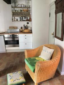 eine Küche mit einem Korbstuhl und einem Tisch in der Unterkunft Klosterhäuschen in Stralsund in Stralsund