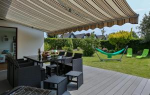 a patio with a table and chairs and a hammock at Hus Möwenschiet in Büsum