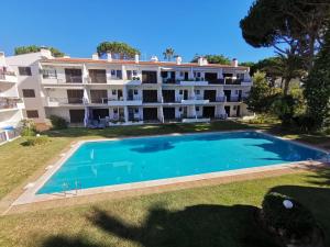 an external view of a large apartment building with a swimming pool at Vilamoura T1 com piscina - Mouramar I in Vilamoura