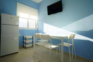 a kitchen with a white table and chairs and a refrigerator at Villa Mimoza in Borsh