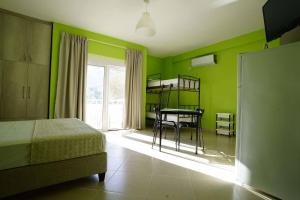 a bedroom with green walls and a bed and a table at Villa Mimoza in Borsh