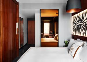 a bedroom with a white bed and a mirror at Hotel Hendricks in New York