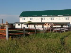 a white building with a green roof and a fence at Білий лебідь in Pulemets