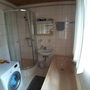a bathroom with a shower and a sink and a washing machine at Apartment on Johannes-Gasse in Gmunden