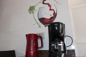 a red coffee maker and a glass of wine on a counter at Casa Feliz en el complejo Las Fresas in Puerto Rico de Gran Canaria