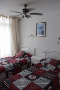 a bedroom with two beds and a ceiling fan at Casa Feliz en el complejo Las Fresas in Puerto Rico de Gran Canaria