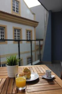 a table with a plate of food and a glass of orange juice at Aveiro2stay in Aveiro