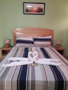 a bed with two white towels on top of it at Gal's Guesthouse in Siquijor