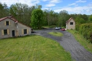 une route vide avec une maison et des voitures garées sur celle-ci dans l'établissement Au Moulin de Rotteleux, à Senarpont