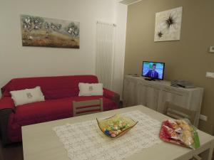 a living room with a red couch and a table at Residenza Ofelia in Vicenza