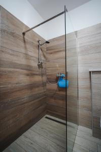 um chuveiro na casa de banho com uma parede de madeira em Apartments Oriana em Rabac