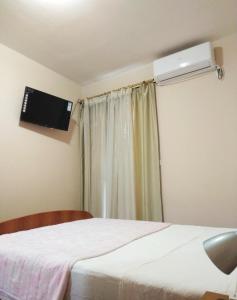 um quarto com uma cama, uma televisão e uma janela em Apartments LUX Milano, Savina,Herceg-Novi em Herceg Novi