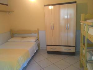 a bedroom with two beds and a cabinet at Guest House Giulio Cesare in Búzios