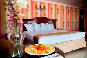 a hotel room with a bed and a plate of fruit on a table at Hotel Plaza Colonial in Campeche