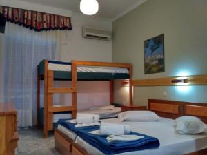 a bedroom with two bunk beds with a ladder at Hotel Livithra in Paralía Skotínis