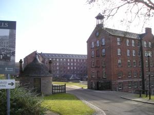 ein großes rotes Backsteingebäude mit einem Uhrturm in der Unterkunft Tayside Hotel in Stanley