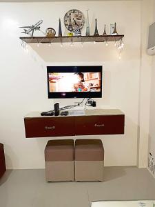 - une télévision installée au-dessus d'un bureau dans l'établissement A Cozy fully furnished PRIVATE ROOM IN CONDOMINIUM unit., à Cebu