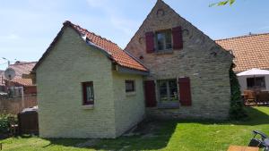 una antigua casa de ladrillo con techo rojo en Chambres d'hôtes du chemin de la maison blanche, en West-Cappel