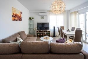 ein Wohnzimmer mit einem Sofa und einem Tisch in der Unterkunft Lindo y acogedor departamento in Torre del Mar