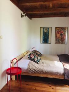 1 dormitorio con cama y taburete rojo en Dom letniskowy w Borach Tucholskich, en Tleń