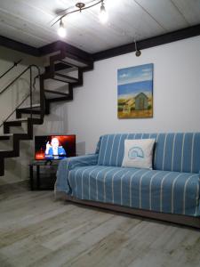 a living room with a couch and a staircase at Sa Costera in Orosei